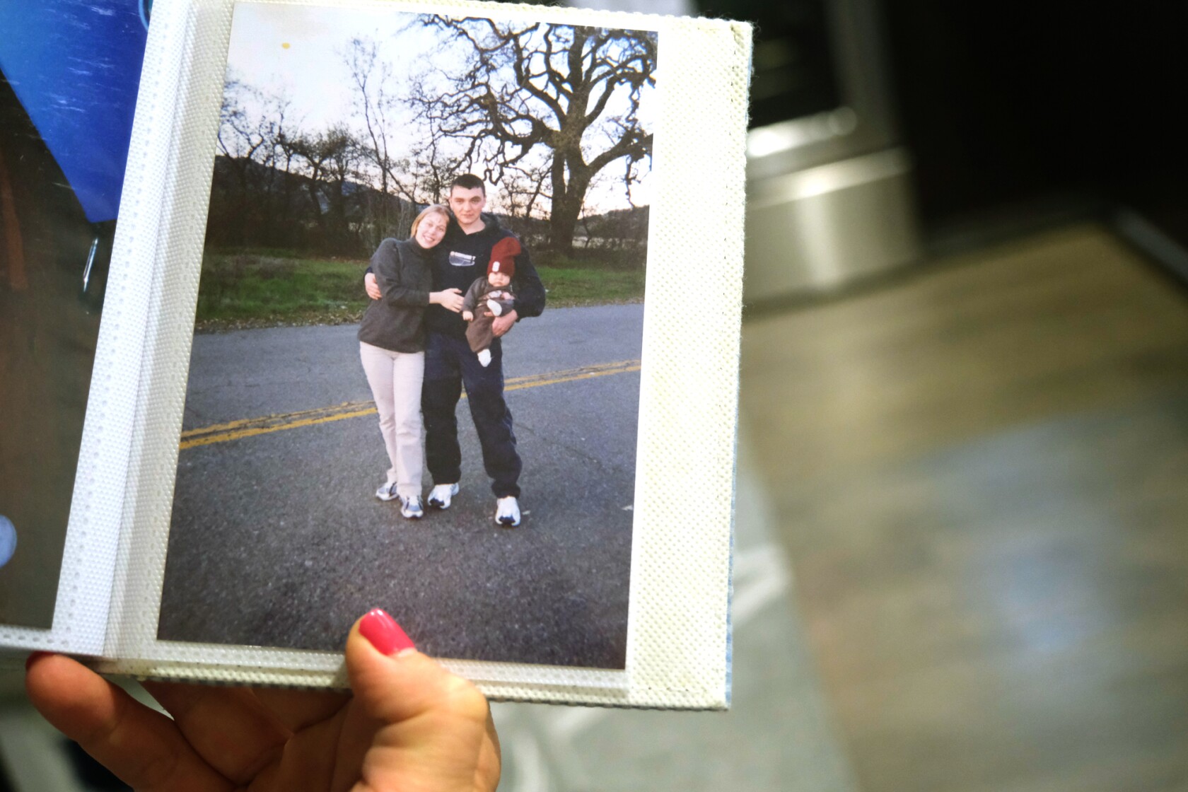 Vasily Keytiyev’s mother, Yuliya Makhnina looks at a photo of herself with Alek Keytiyev, Keytiyev’s father, holding Vasily when he was a baby. San Jose, California.