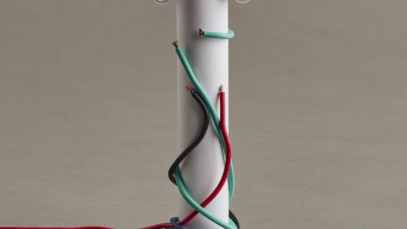 Photo illustration of a classical column built of paper, with colored wires overtaking it like vines of ivy
