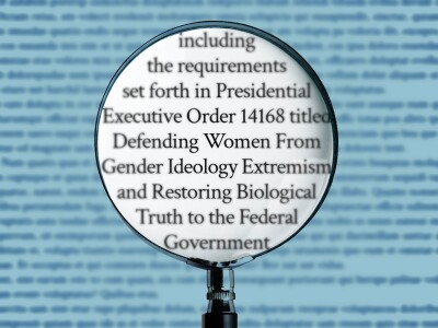 Illustration of a magnifying glass highlighting the phrase "including the requirements set forth in Presidential Executive Order 14168 titled Defending Women From Gender Ideology Extremism and Restoring Biological Truth to the Federal Government."