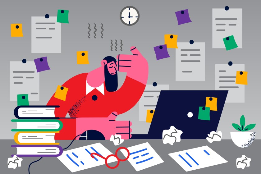 Unhappy stressed male employee sit at desk overwhelmed with work deadline and tasks in office. Frustrated tired man worker overwork at workplace. Fatigue and job stress.