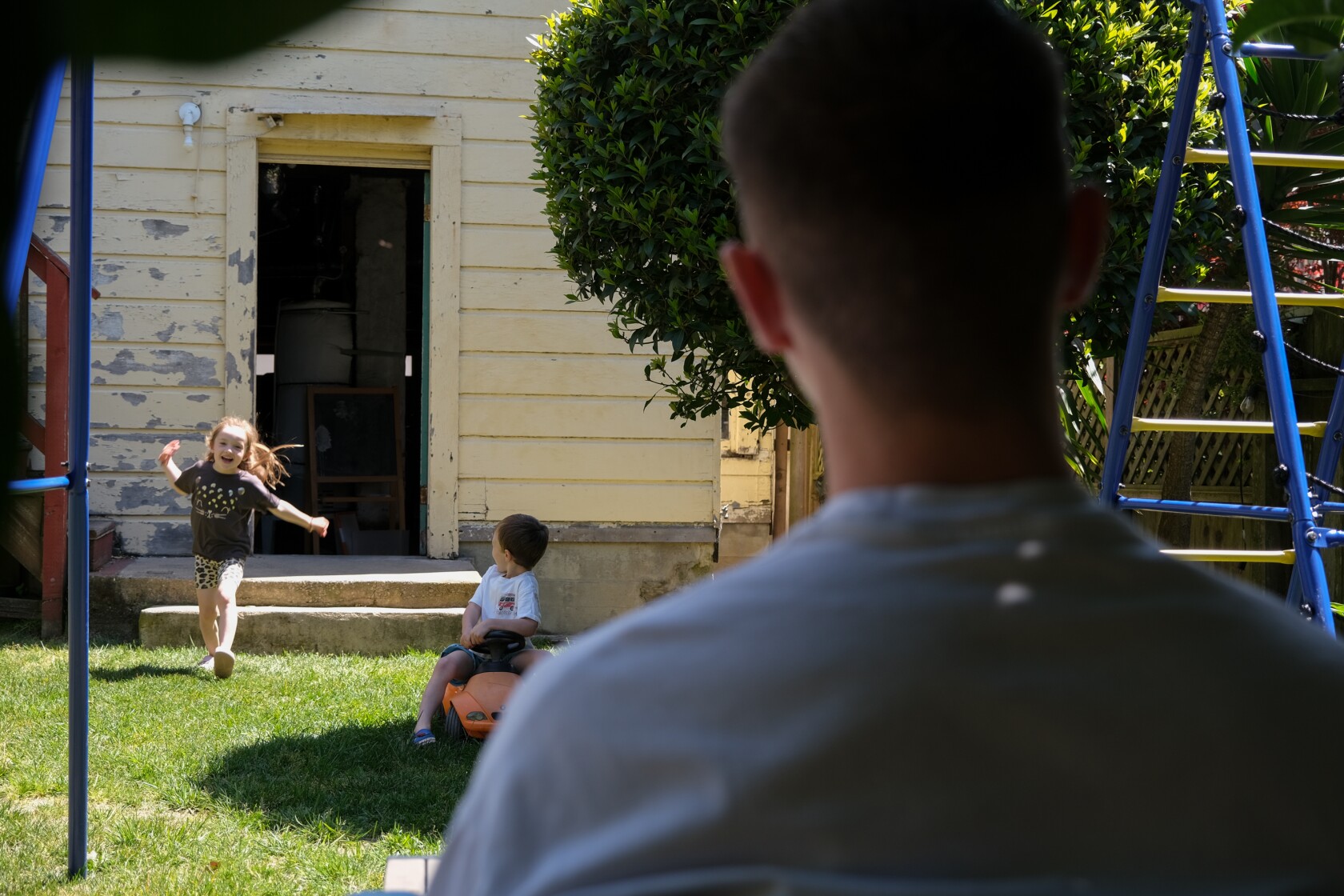 Vasily Keytiyev eats breakfast while siblings, Olivia and Adam Keytiyev play, at his home in San Francisco, California.