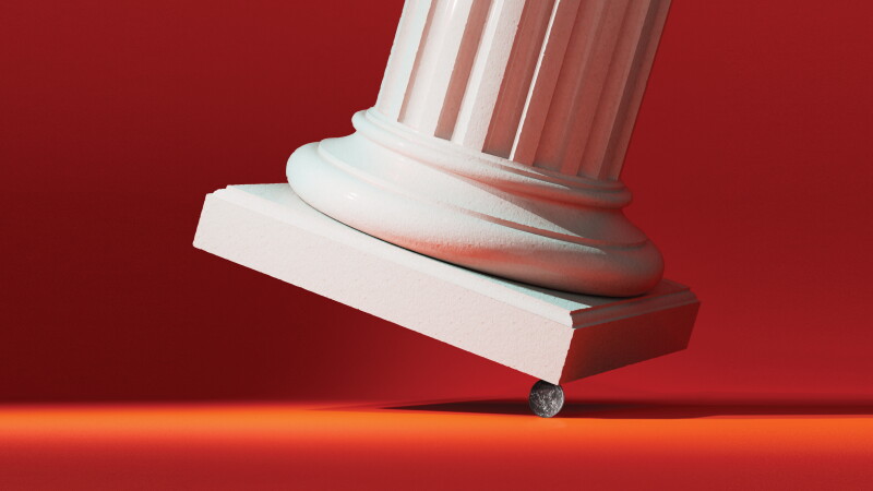 Photo illustration showing a classical column precariously balanced on a dime